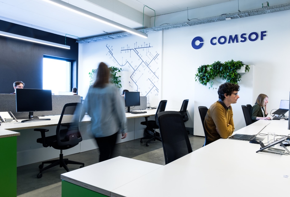 A women walking through an the Comsof office